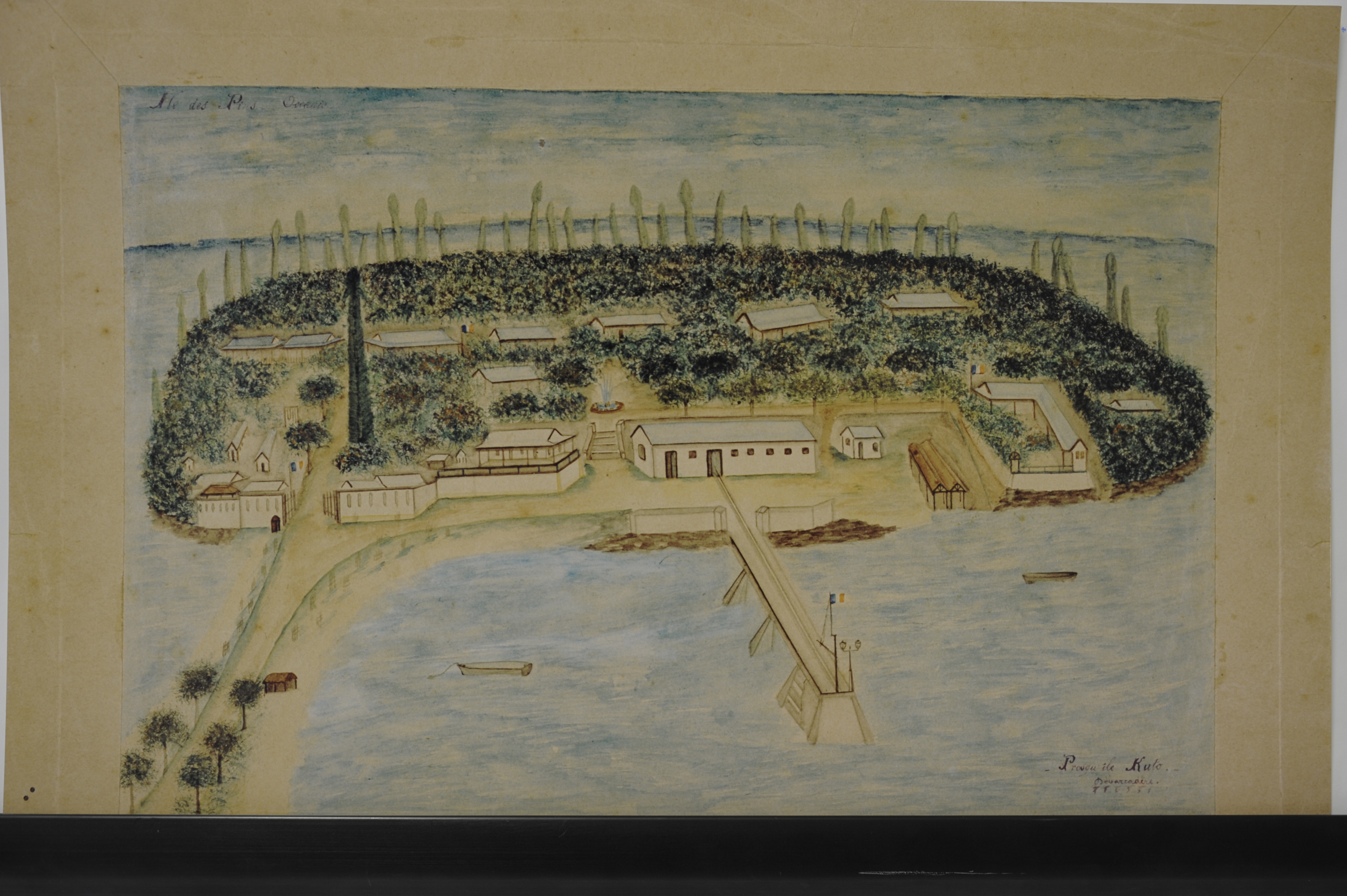 Île des Pins, Kuto, XIXᵉ siècle — Aquarelle représentant l'ensemble pénitentiaire dans son organisation spatiale. La composition révèle l'implantation des bâtiments en alignement au sein de la végétation tropicale. L'accès principal, situé sur la partie gauche de la vue, est signalé par la présence d'un grand araucaria ou pin colonnaire caractéristique. L'entrée centrale, desservie par un escalier, conduit à une place d'honneur agrémentée d'une fontaine. Au premier plan, l'infrastructure portuaire se compose d'un débarcadère qui se prolonge vers les eaux profondes par un ouvrage de trois piles maçonnées en pierre, supportant un fanal d'éclairage et une grue de déchargement en charpente de bois.

Source : Archives de la Nouvelle-Calédonie, fonds iconographique, côte: 120Fi 1